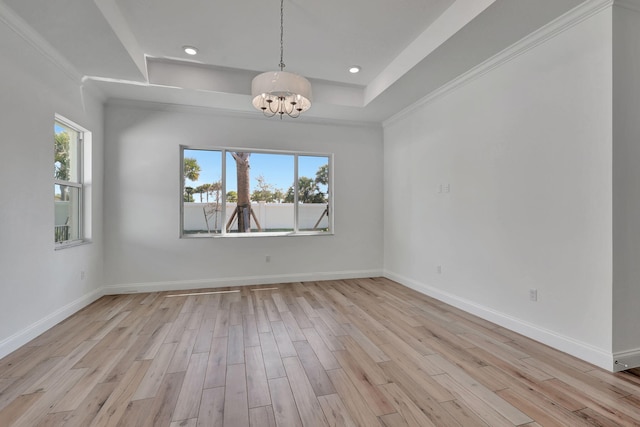 unfurnished dining area featuring light wood-style floors, a raised ceiling, a healthy amount of sunlight, and baseboards