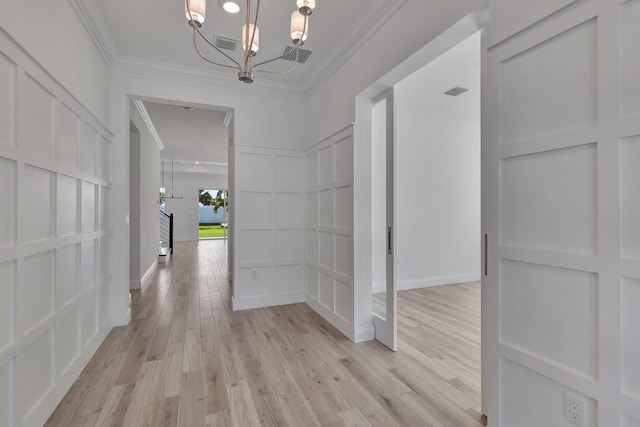 hallway featuring crown molding, light wood-type flooring, visible vents, and a decorative wall