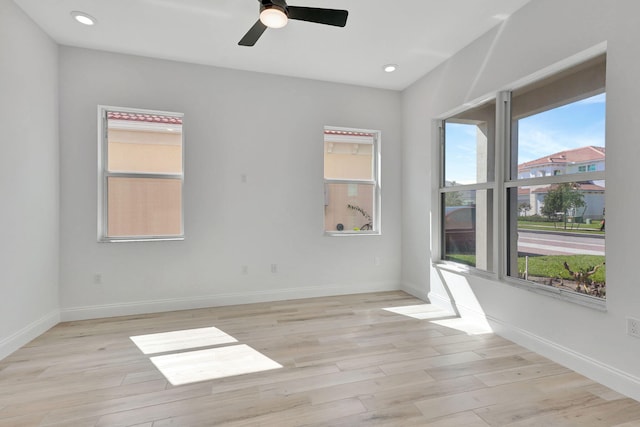 empty room with a healthy amount of sunlight, light wood-type flooring, and baseboards