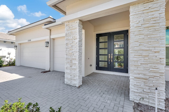 entrance to property featuring a garage and french doors