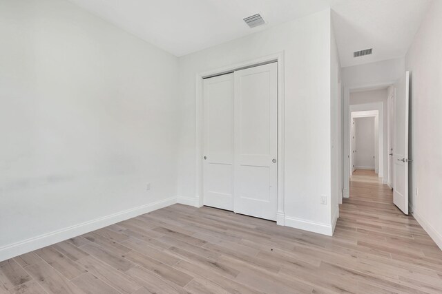 unfurnished bedroom featuring light wood-type flooring, visible vents, and baseboards