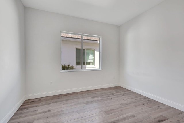 empty room with baseboards and light wood finished floors