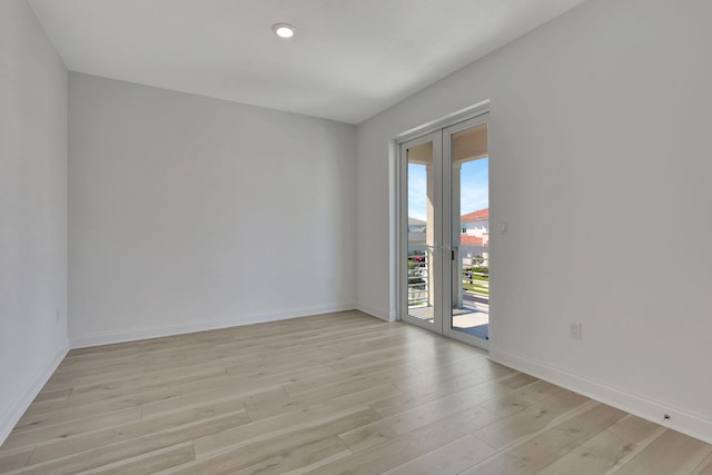 unfurnished room with light wood-type flooring, baseboards, french doors, and recessed lighting