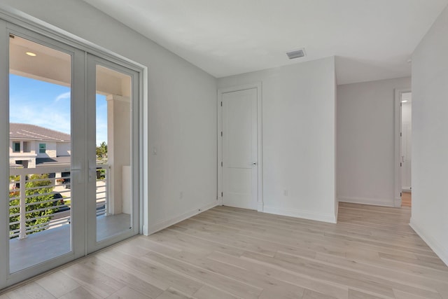 empty room with light wood-style floors, french doors, visible vents, and baseboards