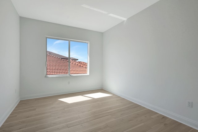 unfurnished room with light wood-type flooring and baseboards