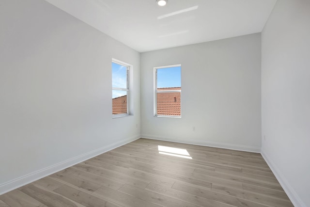 unfurnished room with light wood-style flooring and baseboards