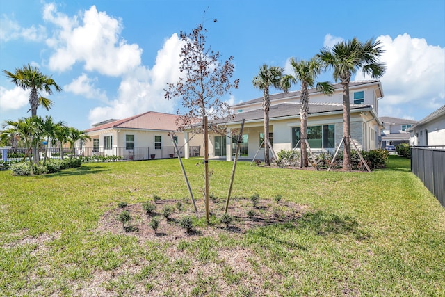 back of property featuring a yard and fence