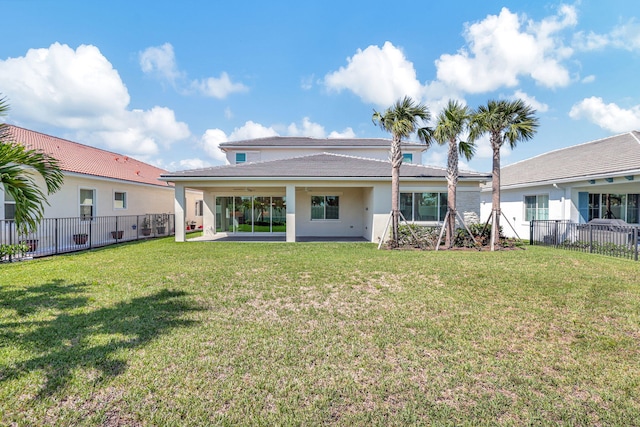 rear view of house featuring a yard, a patio area, and a fenced backyard