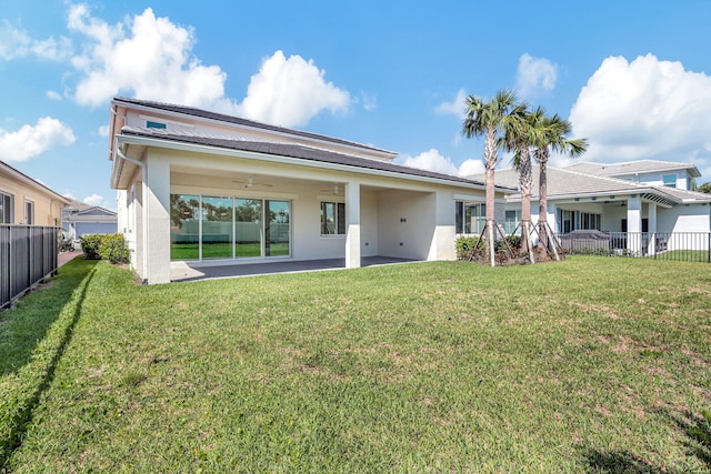 rear view of property with a patio area, a lawn, and fence