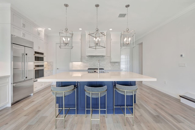 kitchen with stainless steel appliances, light countertops, and white cabinetry