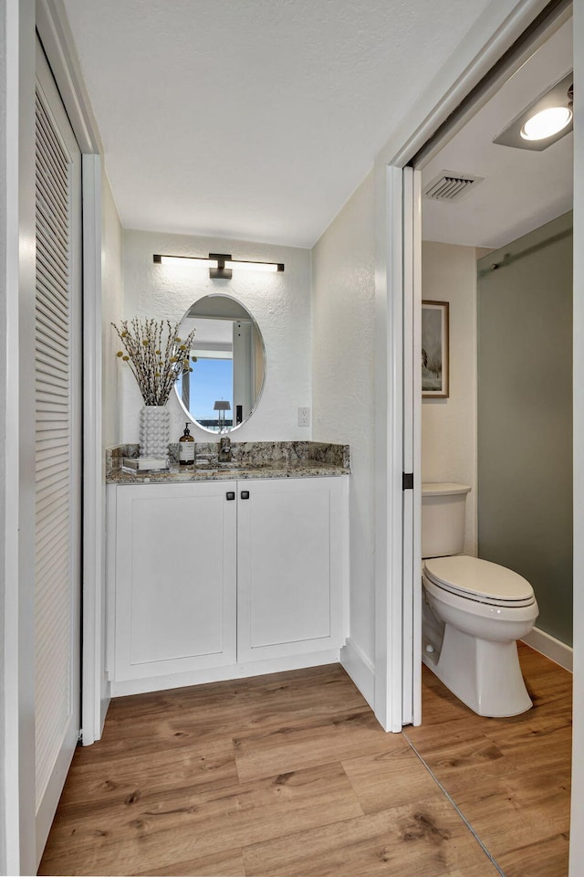 bathroom featuring hardwood / wood-style floors, vanity, and toilet