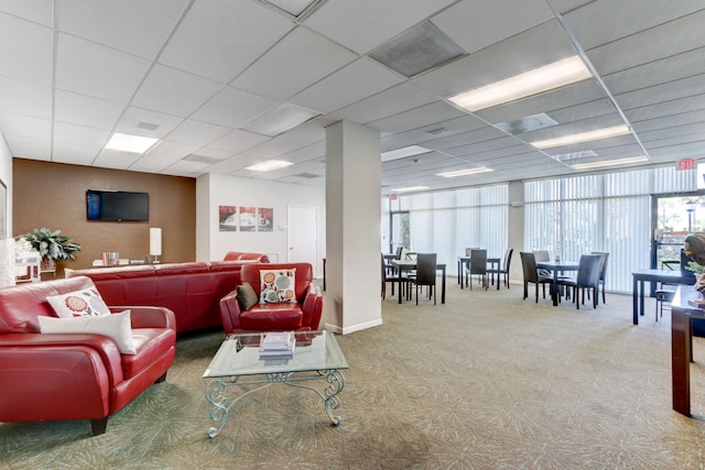 living room featuring carpet flooring, a drop ceiling, and floor to ceiling windows