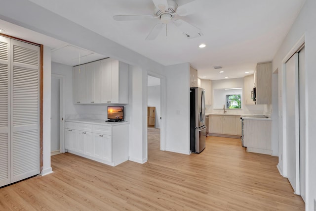 kitchen with stainless steel fridge, light hardwood / wood-style floors, stove, and ceiling fan