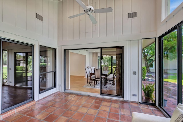 unfurnished sunroom featuring ceiling fan