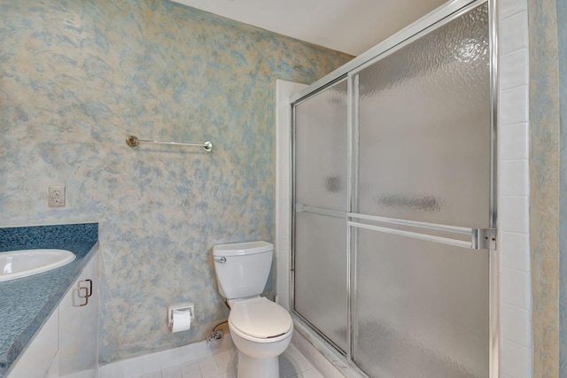 bathroom with vanity, a shower with shower door, toilet, and tile patterned floors