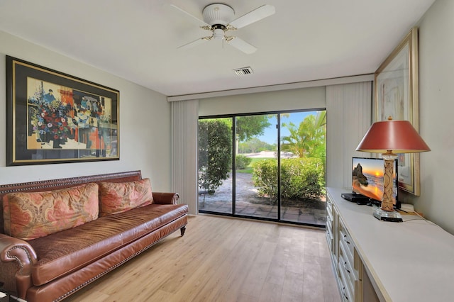 living room featuring light hardwood / wood-style flooring and ceiling fan