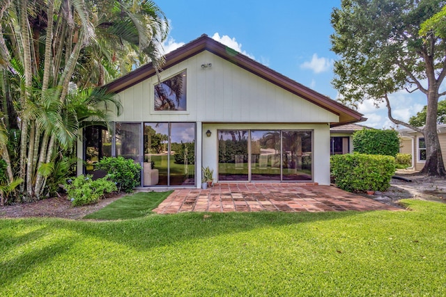 rear view of property with a patio and a lawn