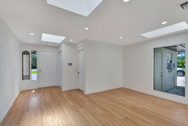 interior space featuring a skylight and light hardwood / wood-style flooring