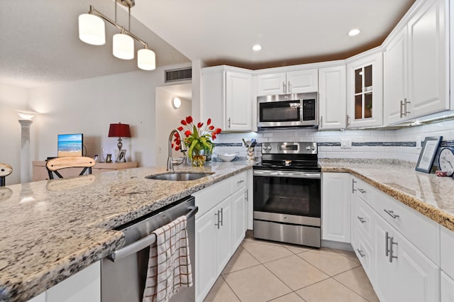 kitchen with sink, white cabinets, pendant lighting, and appliances with stainless steel finishes