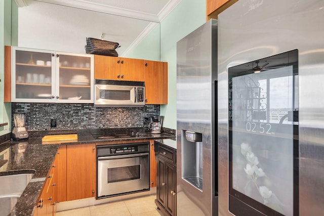 kitchen featuring crown molding, ceiling fan, tasteful backsplash, light tile patterned flooring, and stainless steel appliances