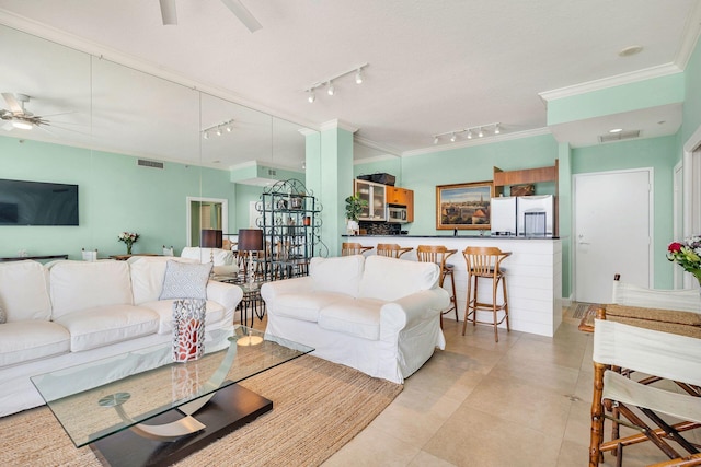 living room featuring light tile patterned floors, track lighting, ceiling fan, and crown molding