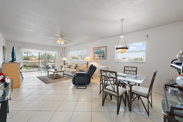 dining room with light tile patterned floors, ceiling fan, and a textured ceiling