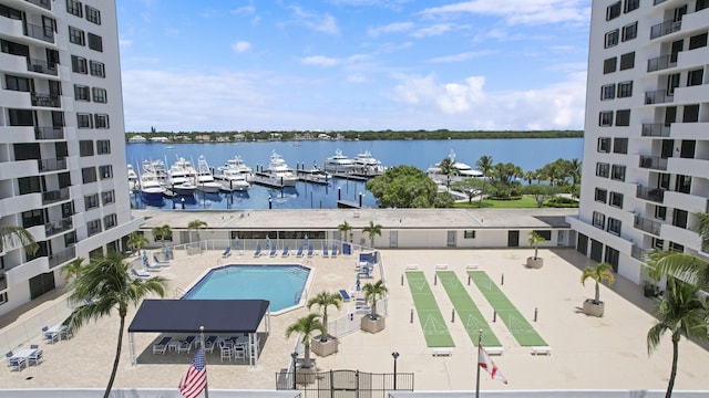 view of swimming pool with a water view and a patio