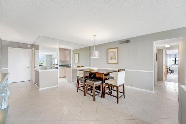 tiled dining space featuring a textured ceiling