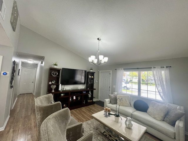 living room with a chandelier, a textured ceiling, hardwood / wood-style flooring, and lofted ceiling