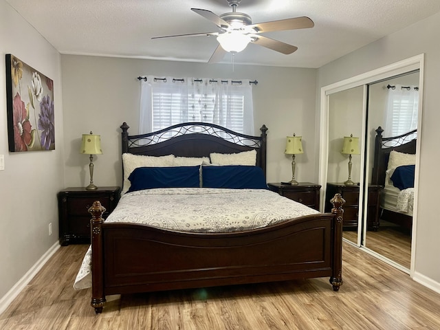 bedroom with ceiling fan, wood-type flooring, a textured ceiling, and a closet