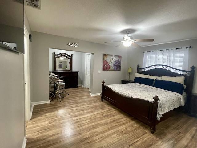 bedroom with ceiling fan, a textured ceiling, and light wood-type flooring