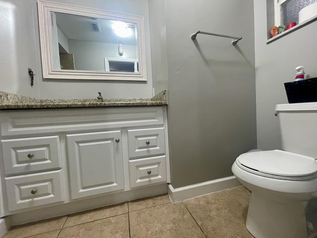 bathroom with tile patterned flooring, vanity, and toilet