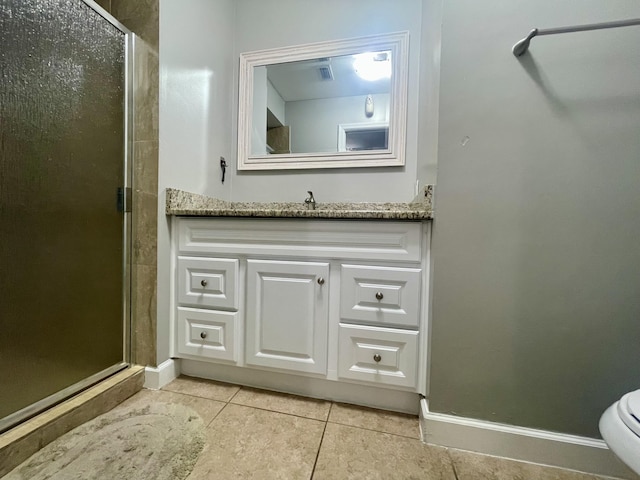 bathroom with tile patterned flooring, vanity, toilet, and walk in shower