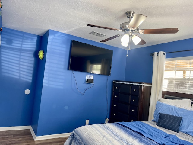 bedroom with wood-type flooring, a textured ceiling, and ceiling fan