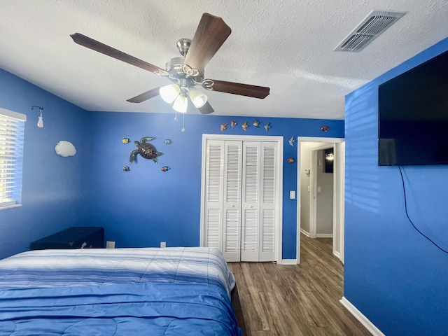 bedroom featuring a textured ceiling, a closet, ceiling fan, and hardwood / wood-style flooring