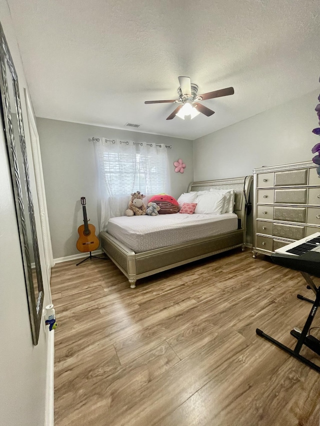 bedroom featuring wood-type flooring, a textured ceiling, and ceiling fan