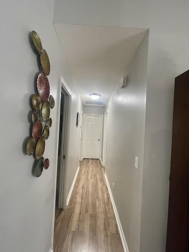 corridor with light hardwood / wood-style flooring