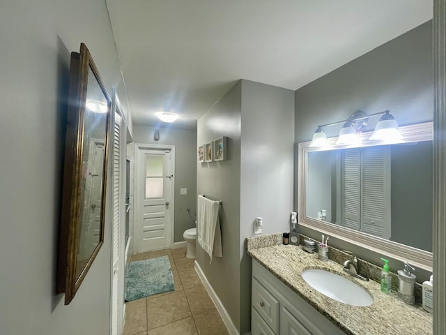 bathroom featuring tile patterned flooring, vanity, and toilet