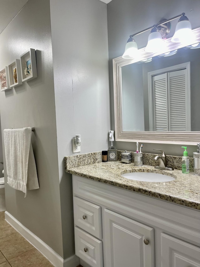 bathroom with tile patterned flooring, vanity, and toilet