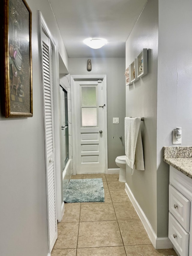 full bathroom with toilet, vanity, tile patterned floors, and shower / bath combination with glass door