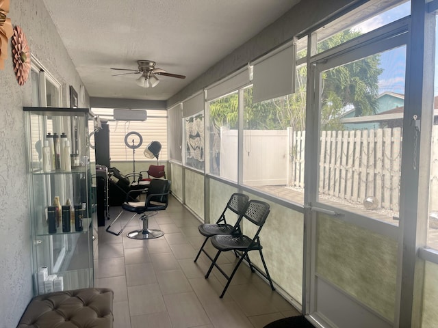 sunroom / solarium featuring a wall mounted air conditioner and ceiling fan