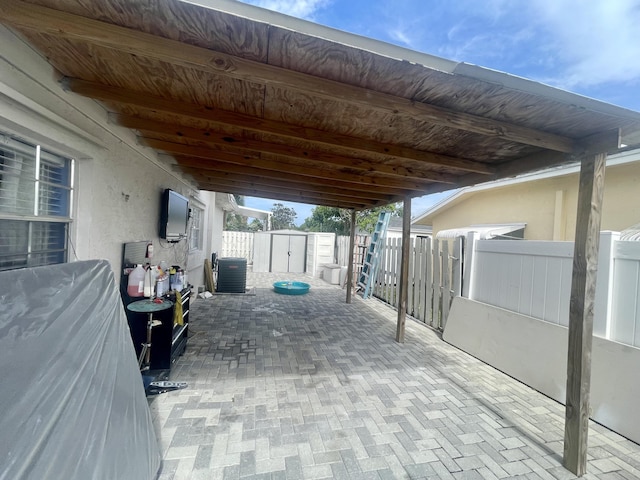 view of patio with a storage unit and central AC unit