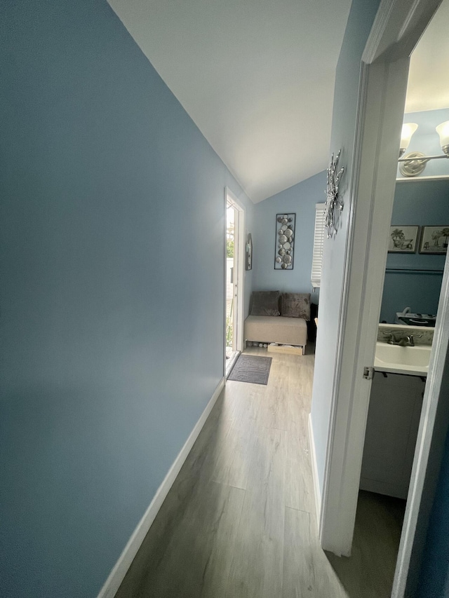 hall featuring light hardwood / wood-style floors and lofted ceiling