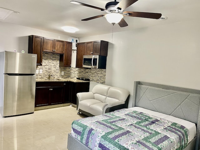 bedroom with ceiling fan, sink, and stainless steel refrigerator