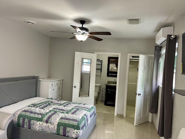 bedroom featuring a wall unit AC, ceiling fan, and ensuite bathroom