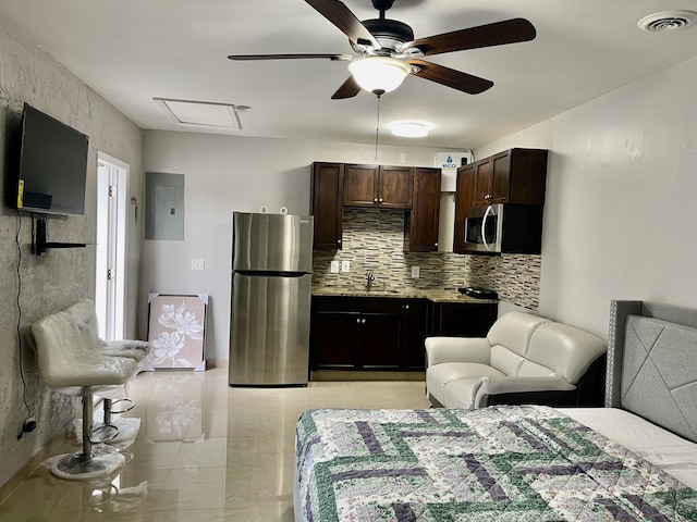 interior space with ceiling fan, sink, stainless steel appliances, backsplash, and electric panel