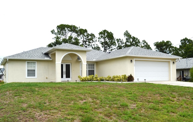 ranch-style house featuring a front lawn, a garage, and french doors