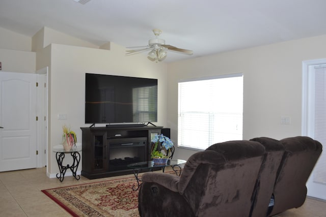 tiled living room featuring ceiling fan and a fireplace