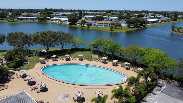 view of swimming pool featuring a water view and a patio area