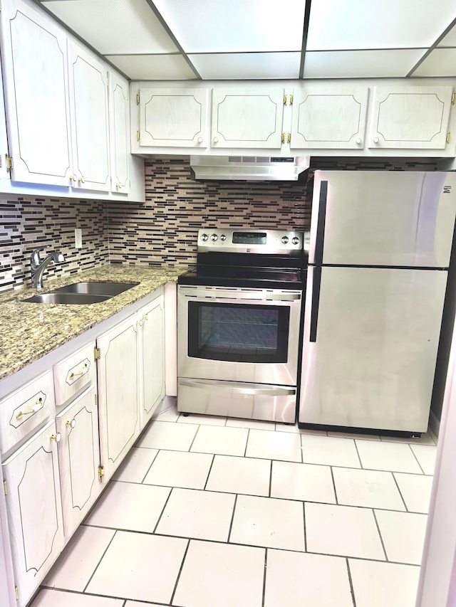 kitchen with appliances with stainless steel finishes, sink, white cabinetry, a paneled ceiling, and range hood